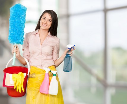 Cleaner wearing PPE while applying carpet treatment safely